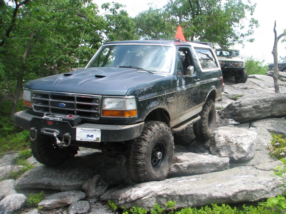 1992 Ford Bronco navigating rocky terrain with another Bronco behind it