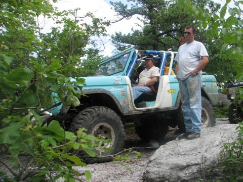 1992 Ford Bronco - A modified first-generation Ford Bronco navigates a rocky off-road course with two onlookers.