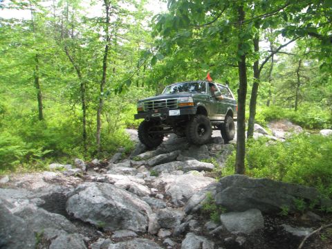 1992 Ford Bronco - This 1992 Ford Bronco navigates a challenging rocky terrain in a forest setting.