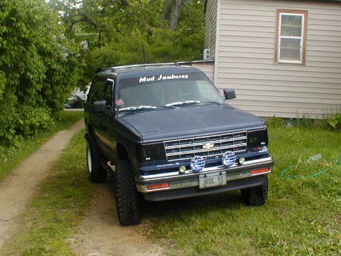 1998 Ford Taurus - This blue Chevrolet S-10 Blazer features off-road tires and a 'Mud Jamboree' banner on the windshield.