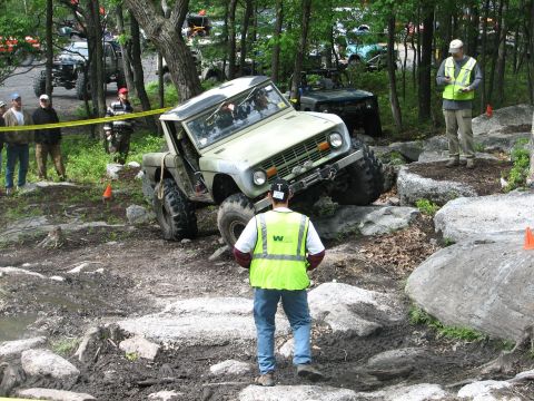 1992 Ford Bronco - An off-road vehicle navigates a challenging rocky course with spectators watching.
