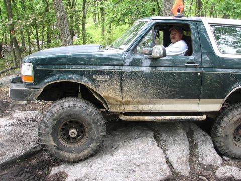 1992 Ford Bronco - Muddy 1992 Ford Bronco navigating a rocky off-road course.