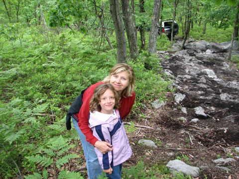 1992 Ford Bronco - A woman and a child pose for a photo in a wooded area with an off-road vehicle visible on the trail.