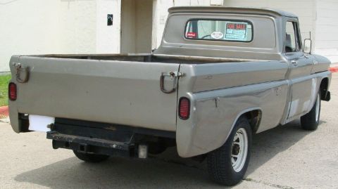 1986 Ford Bronco - A gray pickup truck is viewed from the rear, parked on a paved surface.