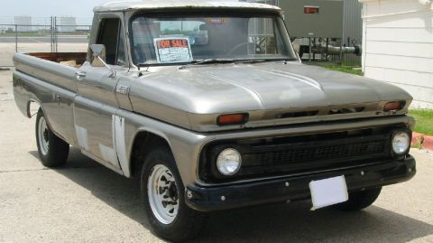 1986 Ford Bronco - This silver pickup truck is parked outdoors with a FOR SALE sign displayed on the windshield.