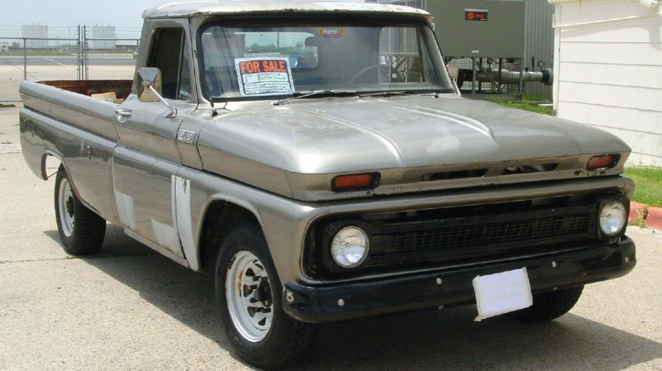 Silver pickup truck with a FOR SALE sign in the window