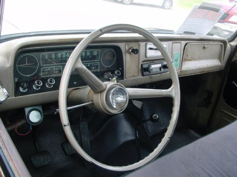 1986 Ford Bronco - The interior of a classic truck features a two-tone dashboard with a large steering wheel and original radio.