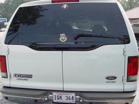 2000 Ford Excursion - White 2000 Ford Excursion Limited SUV seen from the rear, displaying 'EXCURSION Limited' and Ford badging.
