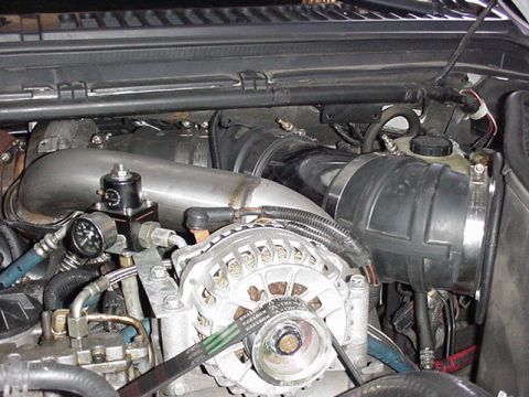 2000 Ford Excursion - Close-up view of engine components including the alternator and air intake system.