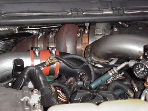 2000 Ford Excursion - Close-up view of an engine's turbocharger system, showing various pipes, hoses, and clamps.