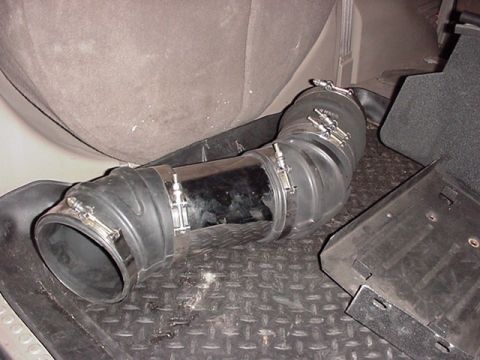 2000 Ford Excursion - Flexible rubber air intake hose with metal clamps and a section of shiny metal pipe.