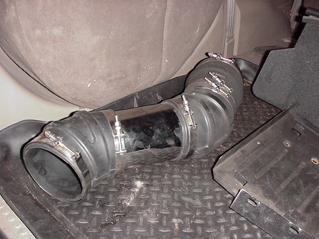 Flexible rubber air intake hose with metal clamps and a section of shiny metal pipe