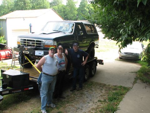 1992 Ford Bronco - Three men stand next to a black Ford Bronco loaded onto a trailer.