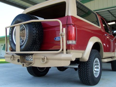 1996 Ford Bronco - Rear view of a red and tan 1996 Ford Bronco, highlighting its spare tire carrier and custom bumper.