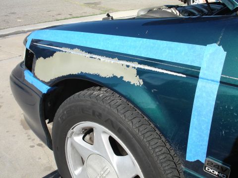 1995 Ford Taurus - Repairing peeling paint on a 1995 Ford Taurus fender, with masking tape applied.