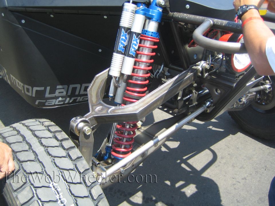 Front suspension of race vehicle with red coilover and blue Fox shocks