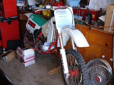1985 Ford Bronco II - Dirt bike for sale in a garage, with "FOR SALE" signs visible on the seat and front fender.