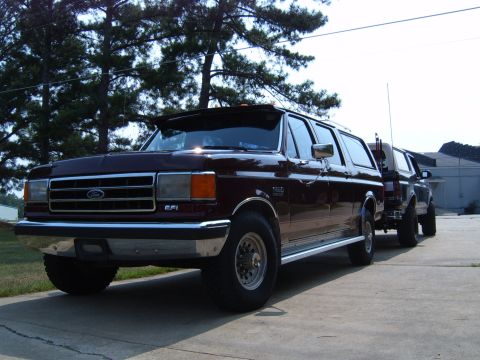 1993 Ford Bronco - This maroon SUV, possibly a custom build, is seen parked alongside another vehicle.
