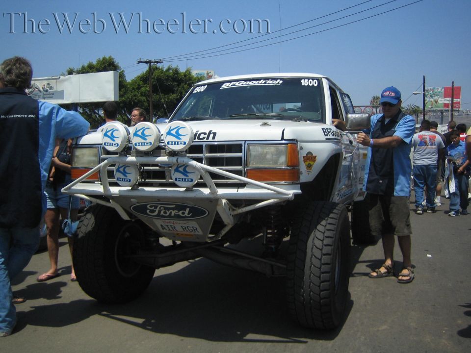 White Ford prerunner race truck no. 1500 with roof light bar and BFGoodrich graphics in a crowd