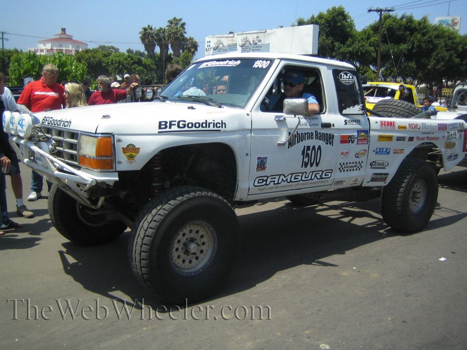 White Ford off-road race truck no. 1500 Airborne Ranger with light bar parked on a street