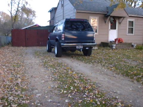 1998 Ford Taurus - SUV parked in front of a house with fallen leaves on the ground.