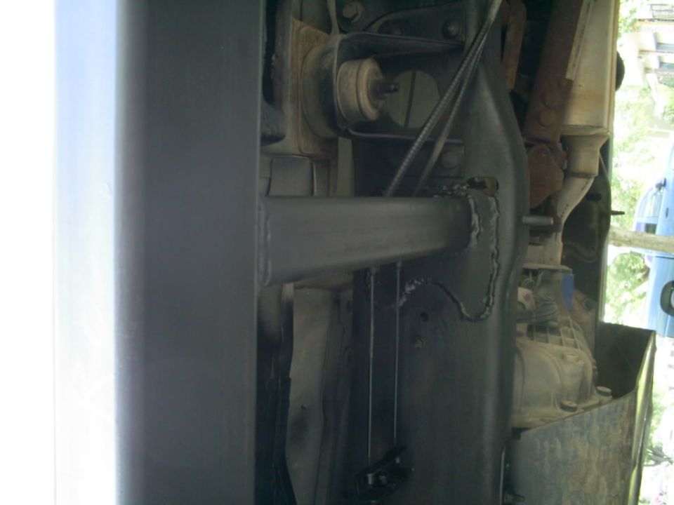 Underside view of vehicle frame with suspension components and exhaust pipe visible. Supermotors.net logo in corner