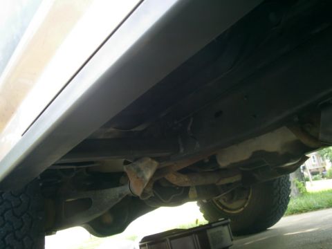 1994 Ford Bronco - The underside of a vehicle is visible, with focus on the frame and exhaust system.