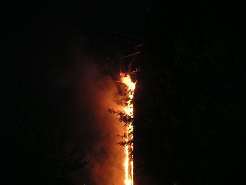 1994 Ford Bronco - A utility pole is on fire at night, with flames and smoke rising into the darkness.