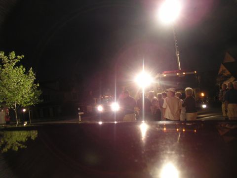 1994 Ford Bronco - A crowd gathers around a vehicle at night, illuminated by a bright overhead light.