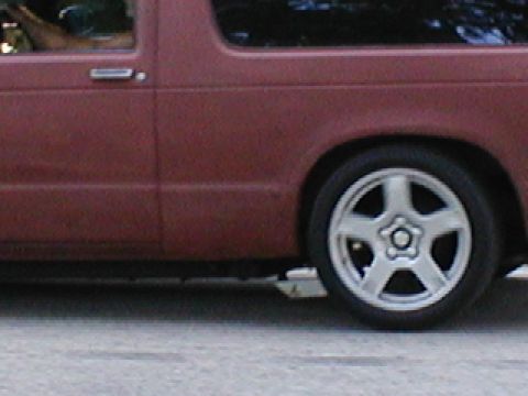 1998 Ford Taurus - Side view of a red pickup truck with custom five-spoke wheels.