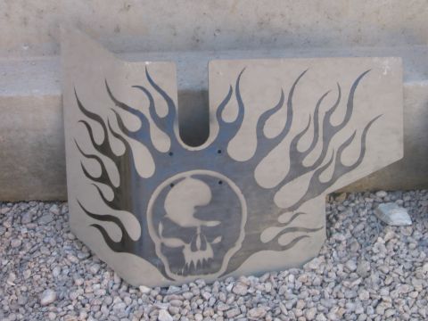 1979 Ford Bronco - A custom metal plate a skull and flame design is displayed outdoors on a gravel surface.