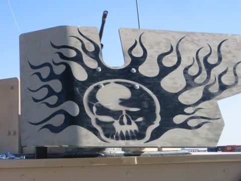 1979 Ford Bronco - Military vehicle part decorated with a skull and flames decal, with a gun barrel protruding.