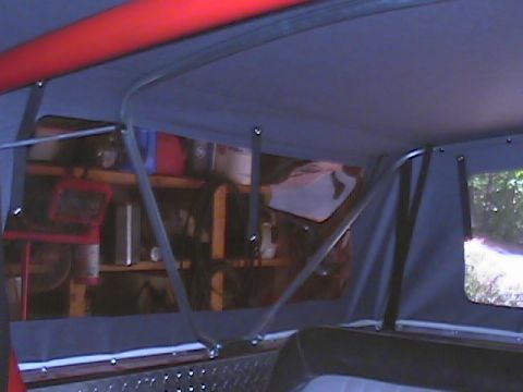 1979 Ford Bronco - Interior view of a vehicle's soft top structure, with shelving visible in the background.
