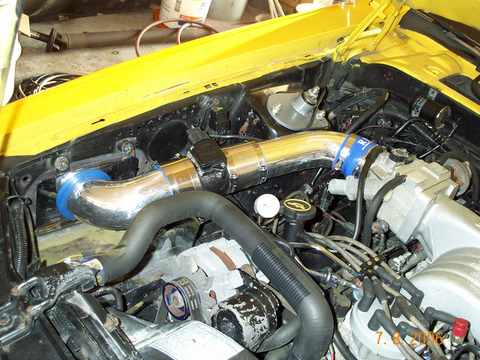 1986 Mercury Cougar - Aftermarket intake system installed in an engine bay, showing chrome piping and blue couplers.