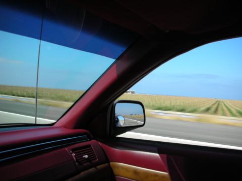 1992 Ford Crown Victoria - View from inside a vehicle looking out at a rural landscape with a field and road.
