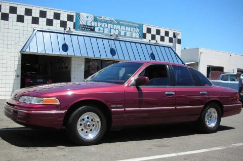 1992 Ford Crown Victoria - A maroon 1992 Ford Crown Victoria is seen from the side in front of the JBA Performance Center.