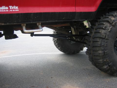 1979 Ford Bronco - Close-up of a modified vehicle's suspension and large tires, with text 'Studio Trix' visible on the body.