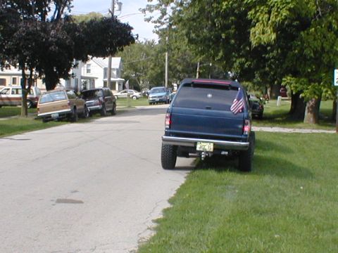1998 Ford Taurus - Blue SUV parked on a residential street with other vehicles present.