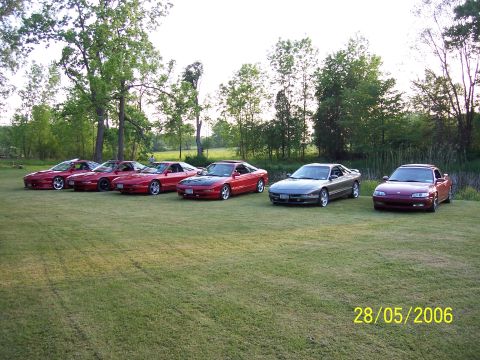 1996 Ford Probe - Several Ford Probes and a Mazda MX-6 are lined up on a grassy field.