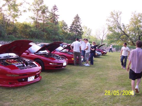 1996 Ford Probe - A group of red 1996 Ford Probes are displayed with their hoods open at an outdoor gathering.