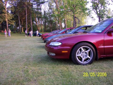 1996 Ford Probe - Several cars are lined up on a grassy field with trees in the background, dated May 28, 2006.