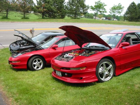 1996 Ford Probe - Multiple Ford Probes are displayed with their hoods open, their engines on a grassy area.