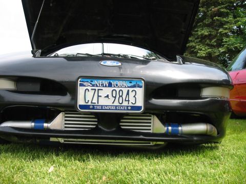 1996 Ford Probe - A black car with its hood up displays custom intercoolers, with another vehicle partially visible in the background.