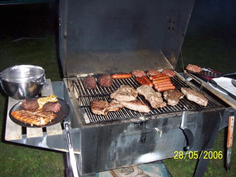1996 Ford Probe - Grill is loaded with various meats including steaks, burgers, and hot dogs.