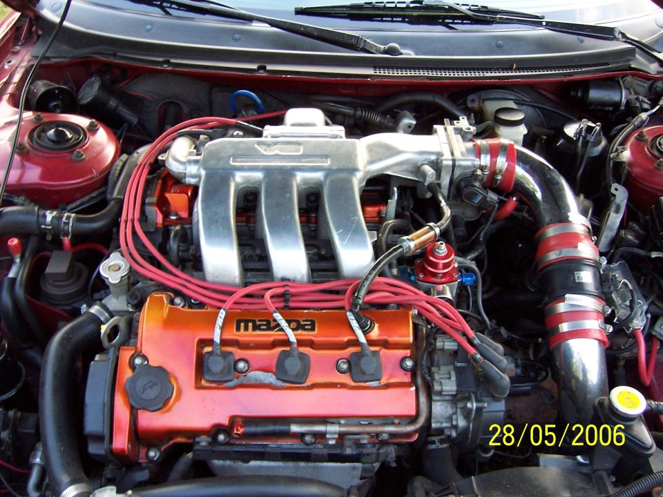 Engine bay with Mazda branding on orange valve cover
