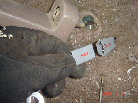 1993 Ford Bronco - Close-up of interior wiring harness connectors being handled.