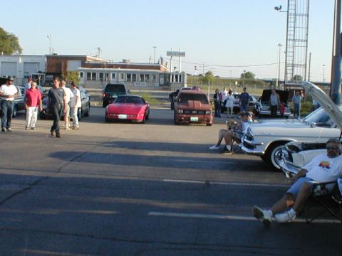 1998 Ford Taurus - Several cars and people are gathered in a parking lot on a sunny day.