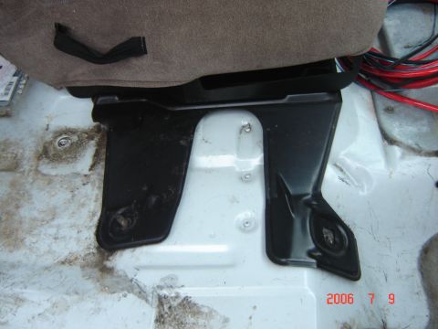1993 Ford Bronco - Close-up of a vehicle seat mounting bracket, showing installation details and wiring.