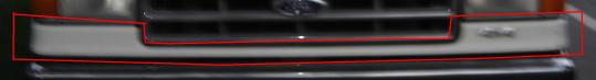 Grille and bumper of a light-colored Ford truck, possibly from the 1980s