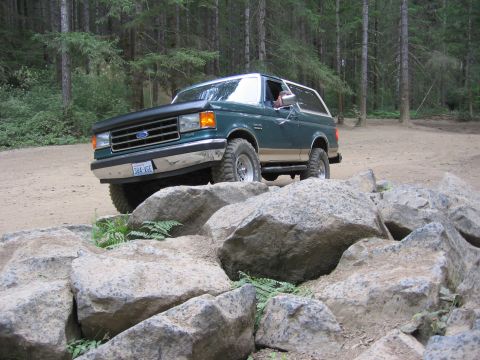 1990 Ford Bronco - This 1990 Ford Bronco is shown tackling a challenging off-road course with large rocks.